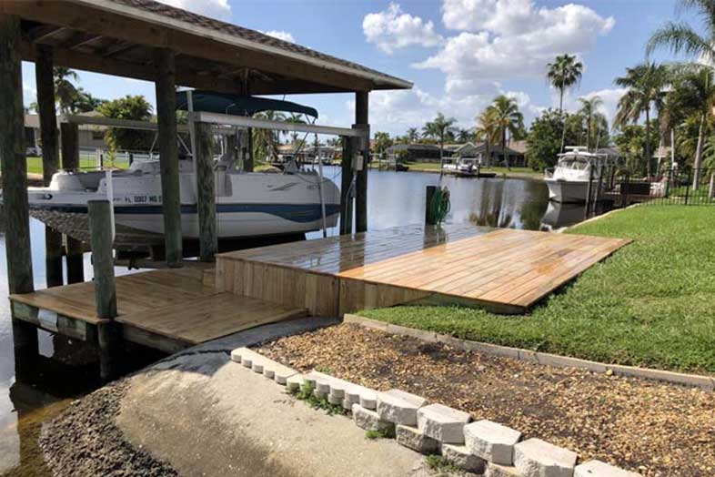 Boat in water in front of boat dock remodeled by SPEC Development